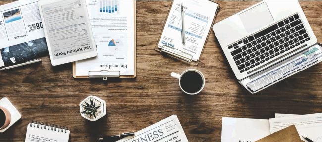 Business desk including a laptop, documents, and office supplies. 